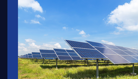 Painéis solares em um campo contra um céu azul brilhante.