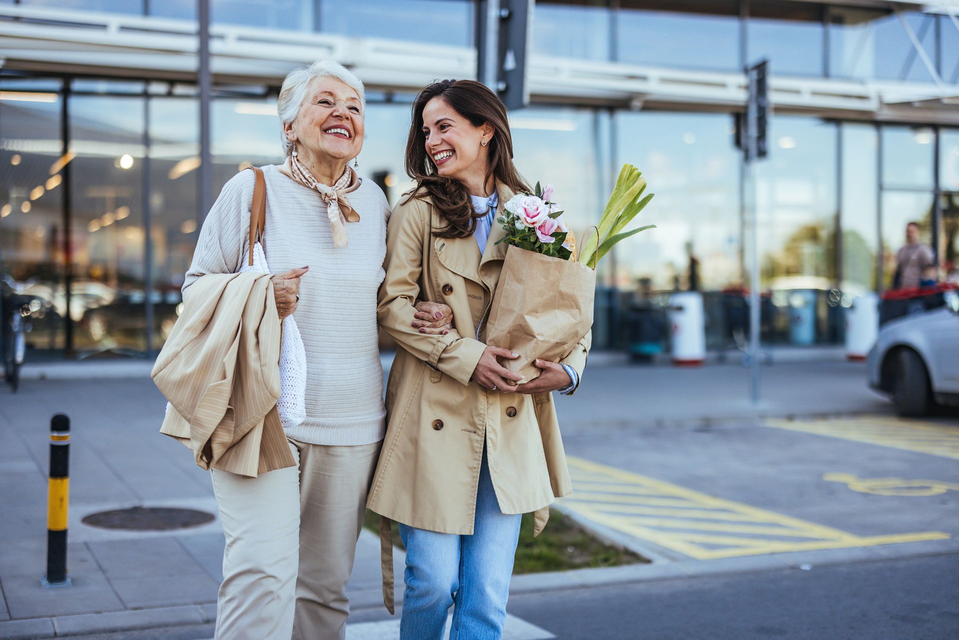 An elderly woman and a young woman are walking down the street.