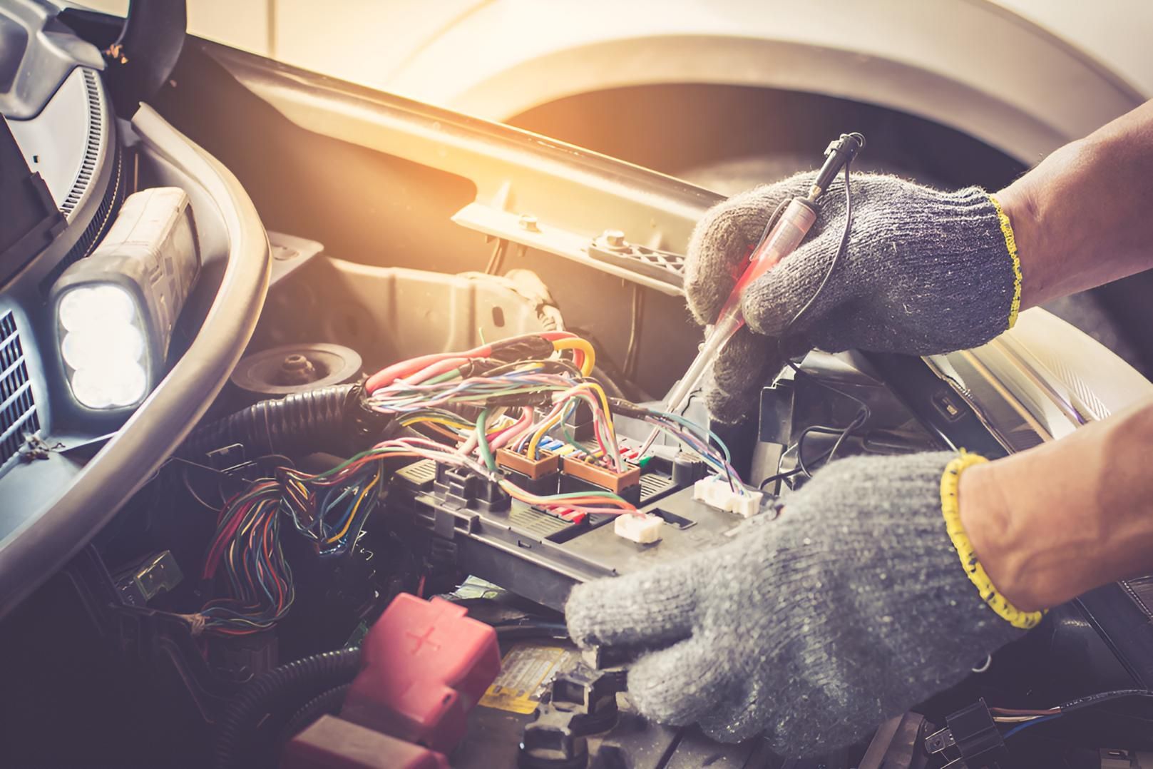 A Person is Working on a Car Battery With a Screwdriver — All things Diesel NT in Tivendale, NT