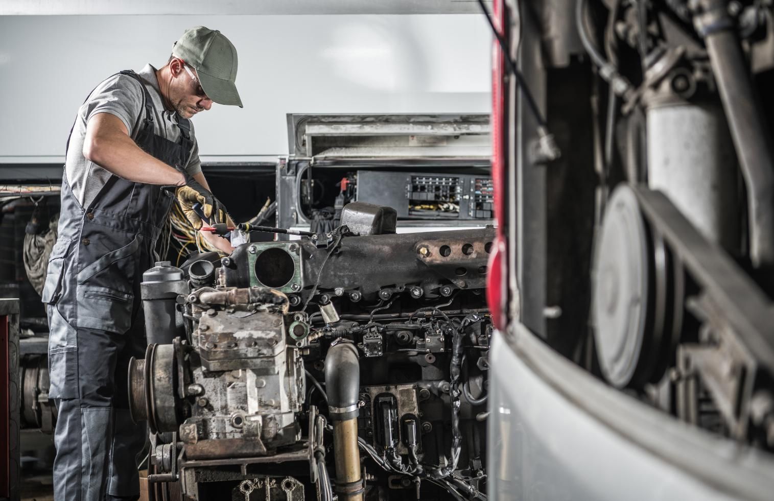 A Man is Working on the Engine of a Bus in a Garage — All things Diesel NT in Tivendale, NT