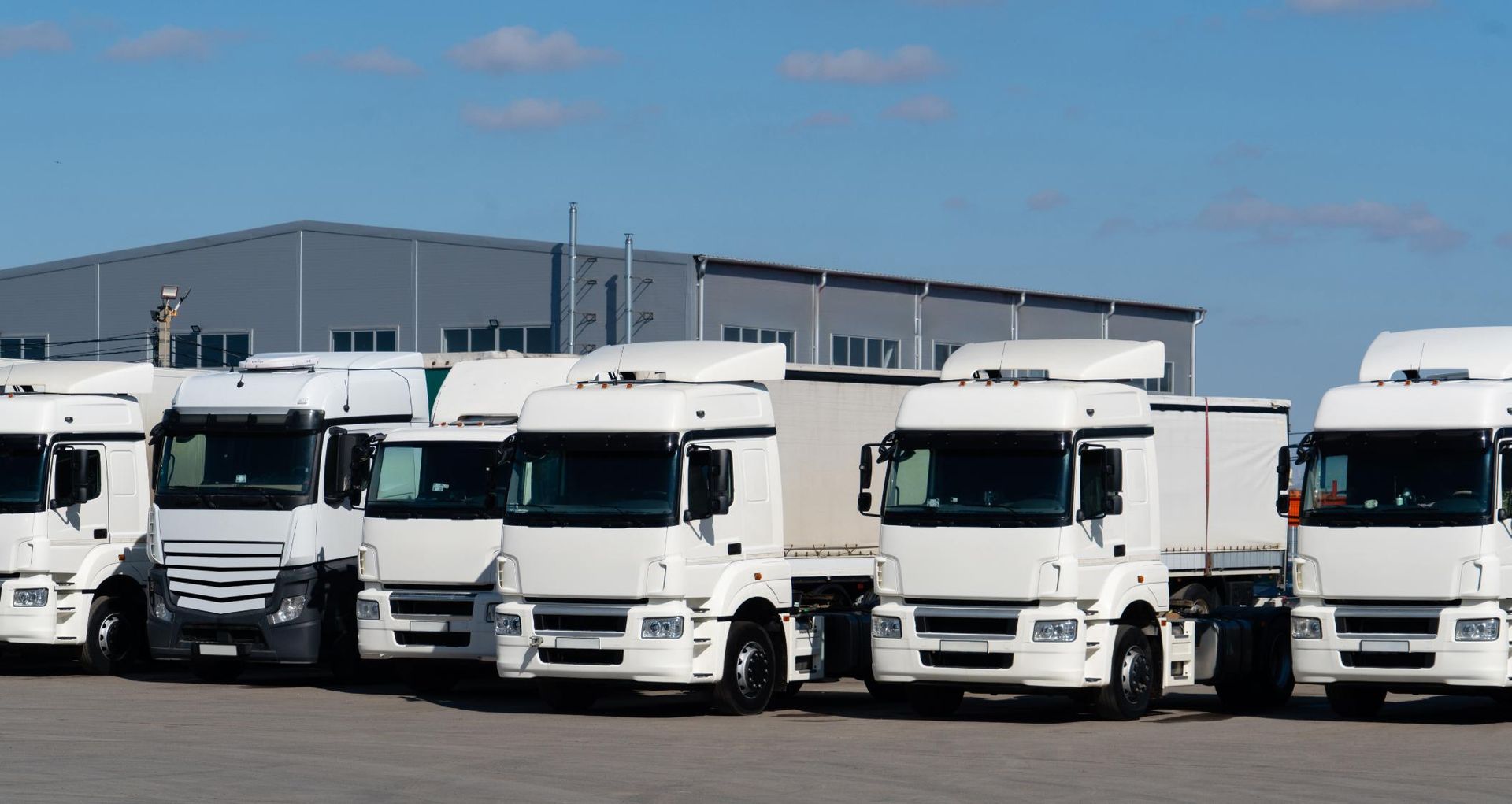 A Row of White Semi Trucks Are Parked in a Parking Lot — All things Diesel NT in Tivendale, NT