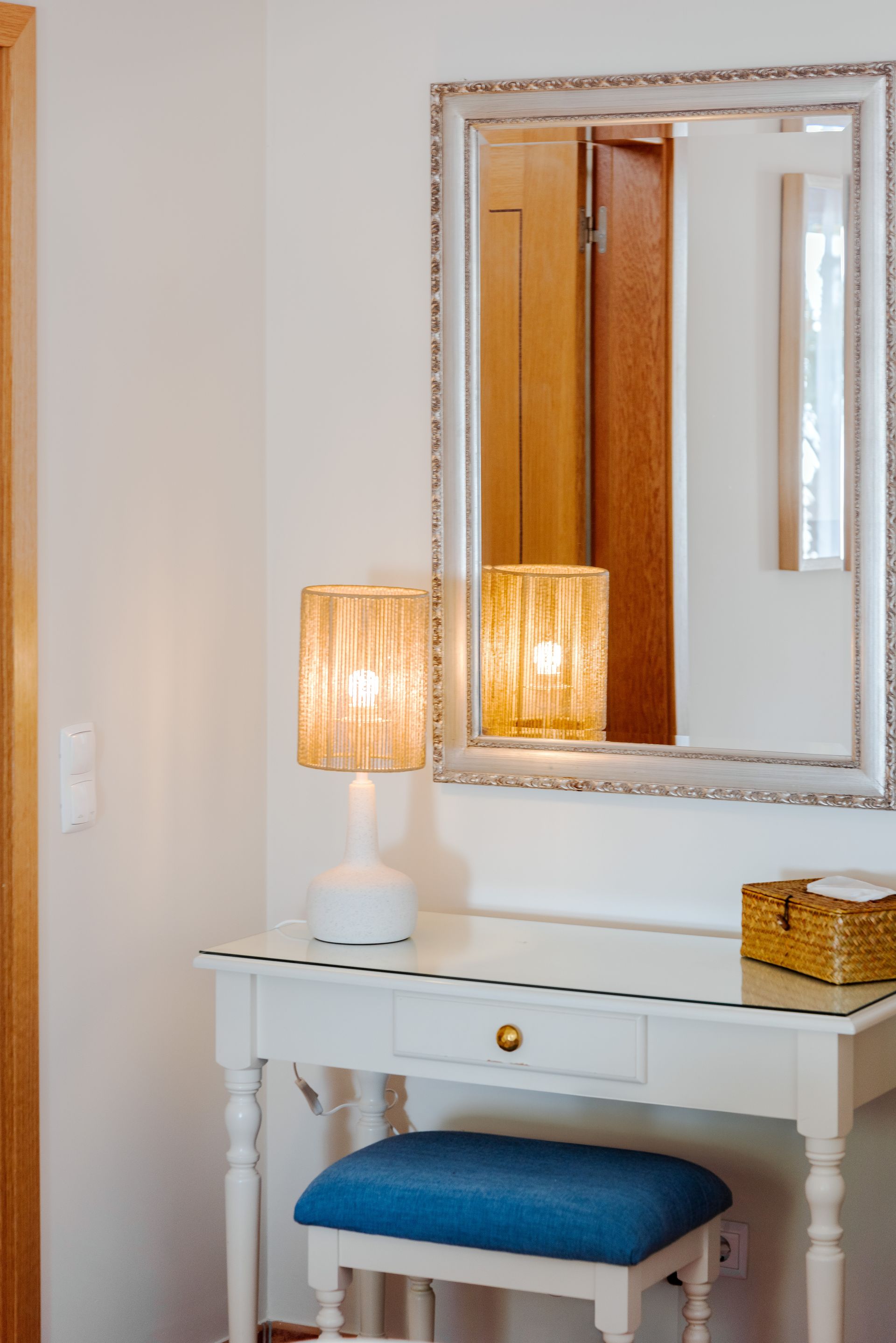 A vanity with a mirror and a lamp on it