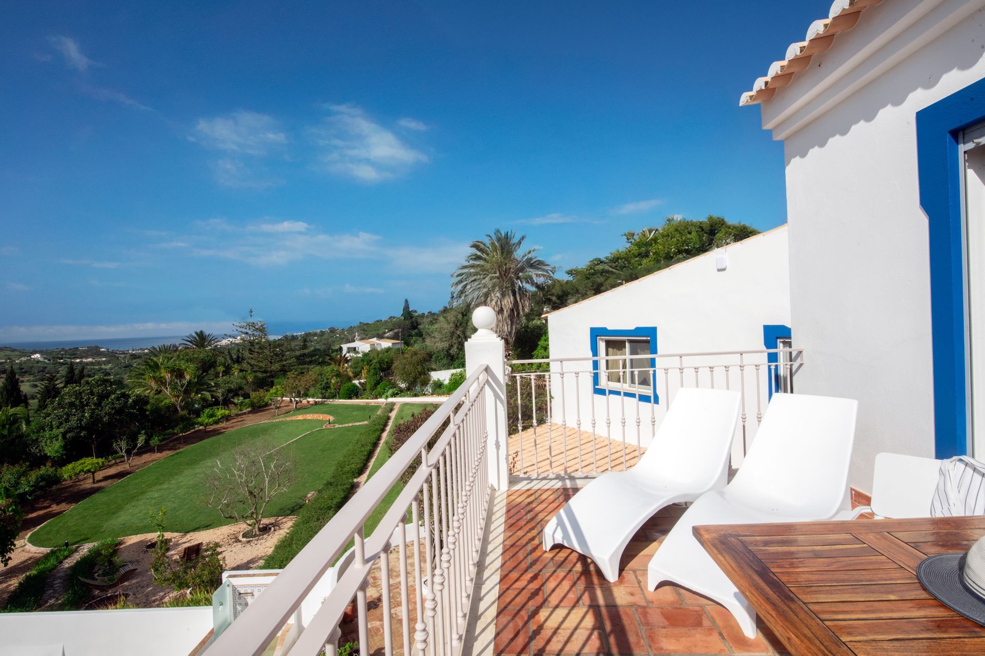 A balcony with chairs and a table with a view of a golf course