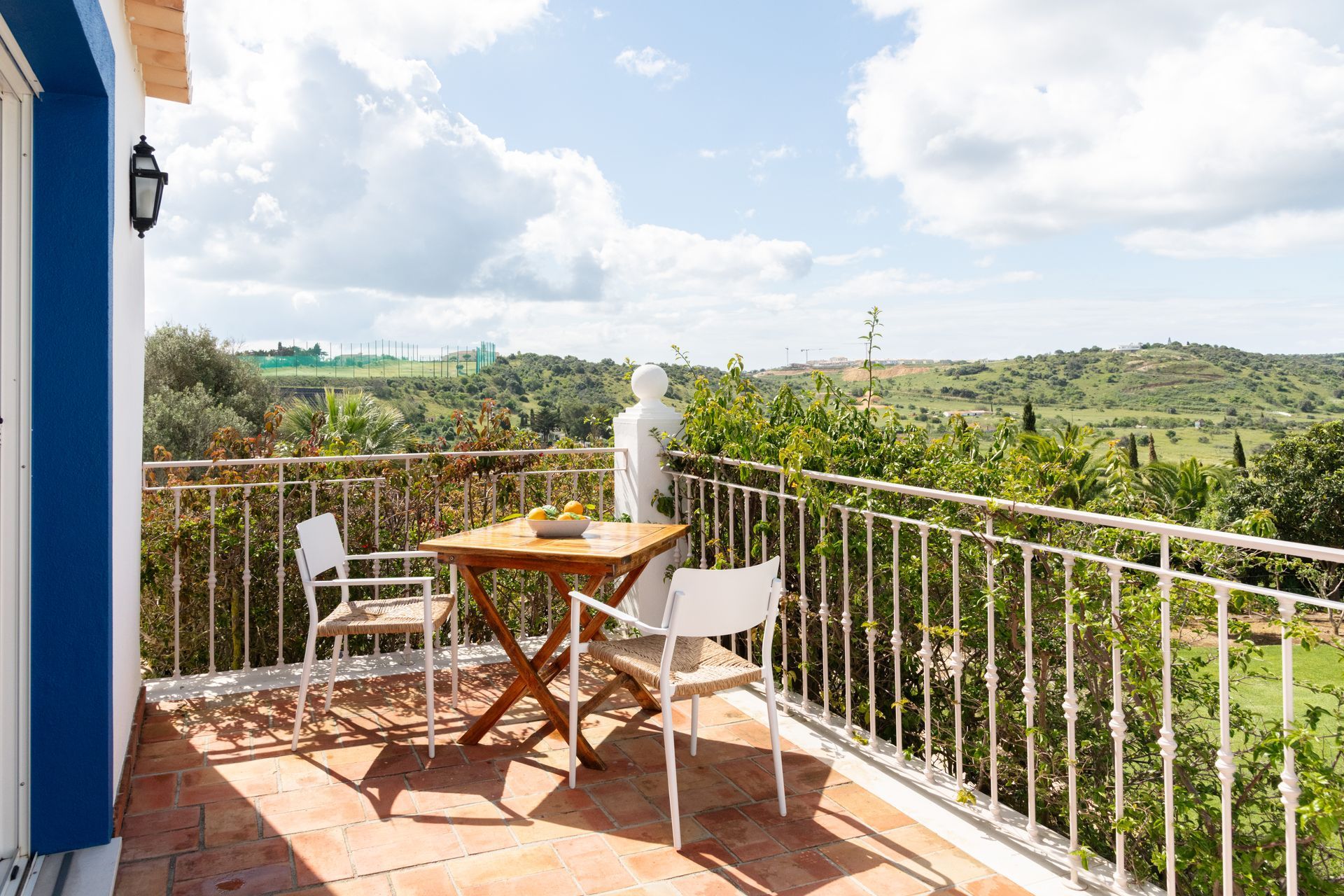 There is a balcony with a table and chairs on it.