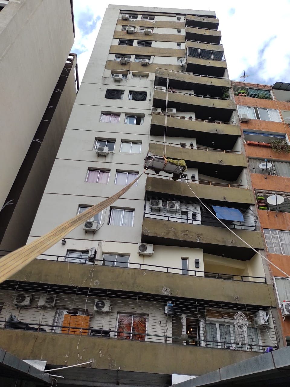 Edificio de apartamentos de gran altura con múltiples balcones, fachada beige y marrón