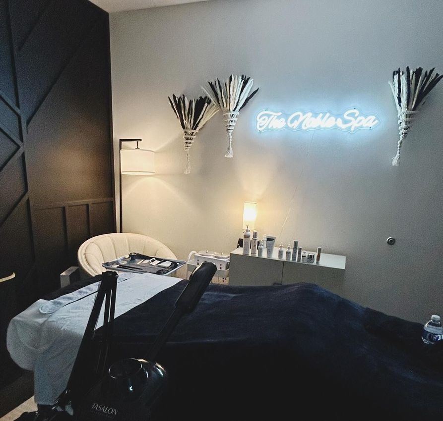 A room with a neon sign that says the noble spa