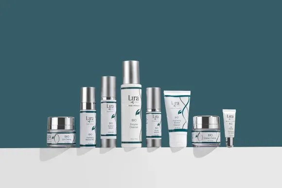 A row of bottles of cosmetics are lined up on a table.
