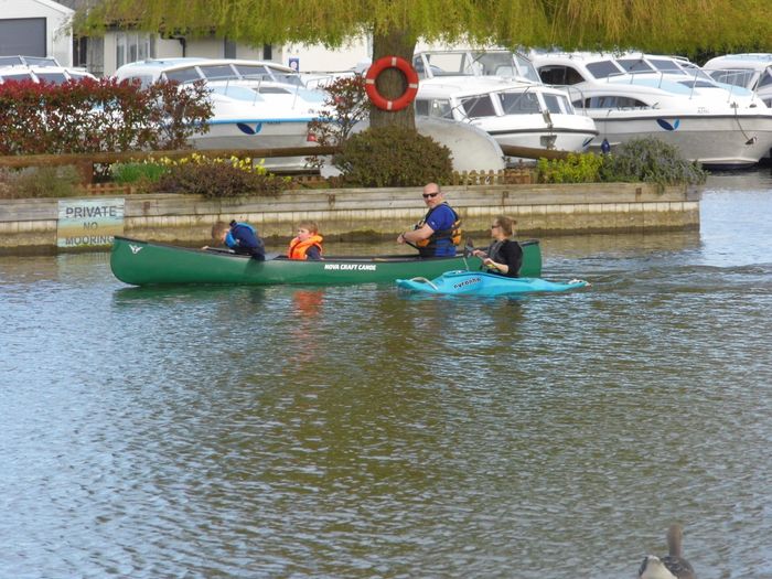 kayak and canoe on calm water on River Bure, Norfolk Broads.