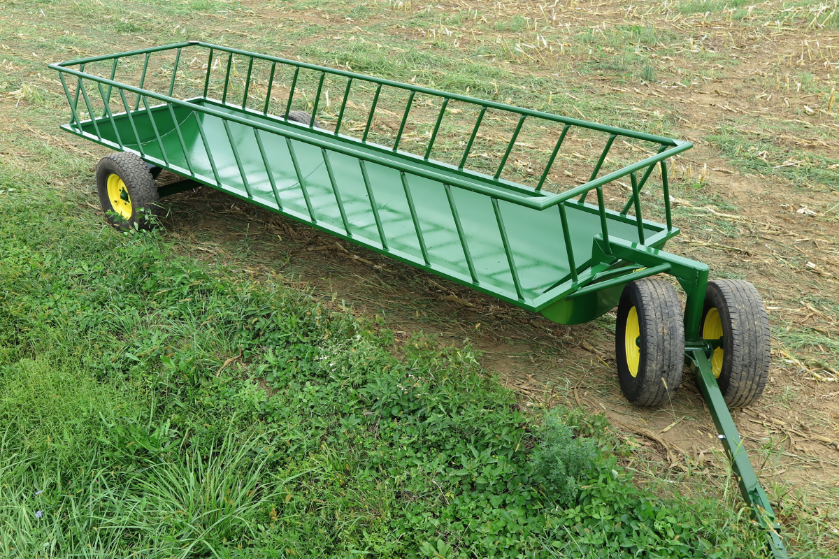 Green cattle feeder wagon with heavy-duty steel construction