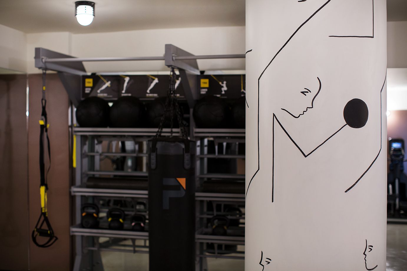 Indoor server room with metal racks, cables, and a white wall marked by a black line drawing.