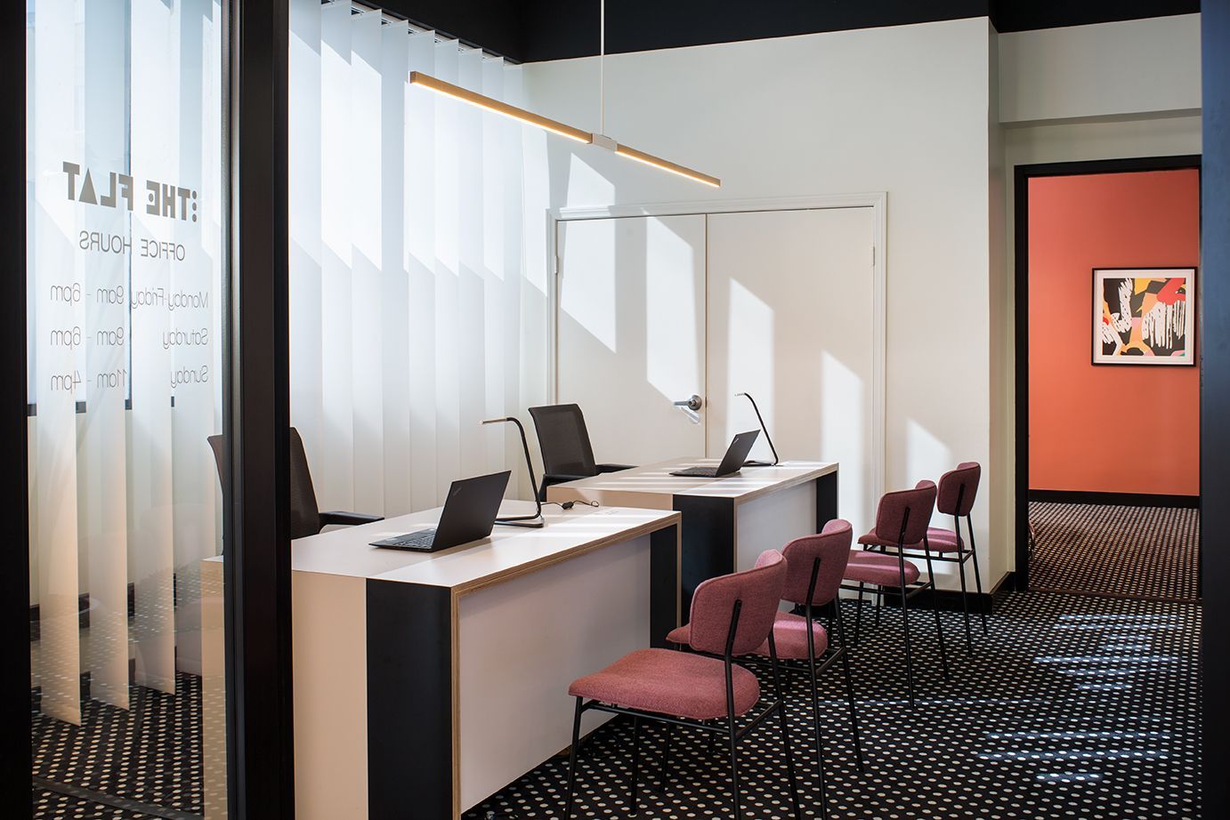 Modern office reception area with desks, chairs, and patterned carpet
