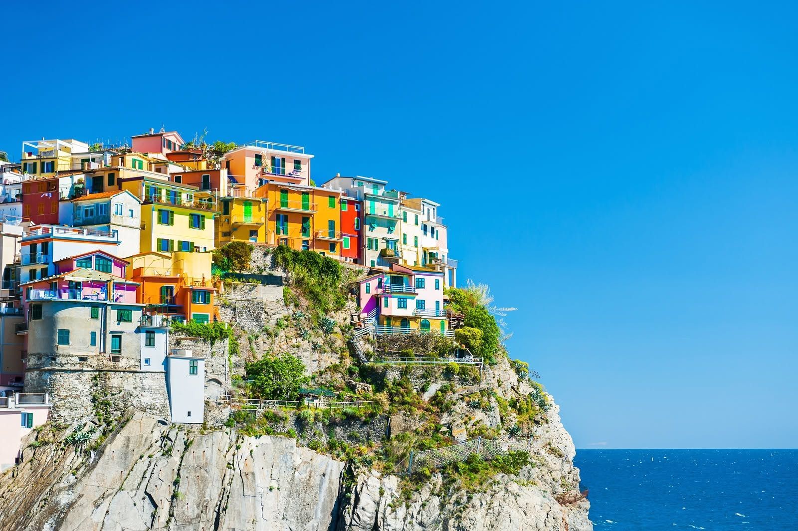 Colorful cliffside village overlooking a blue ocean under a clear sky
