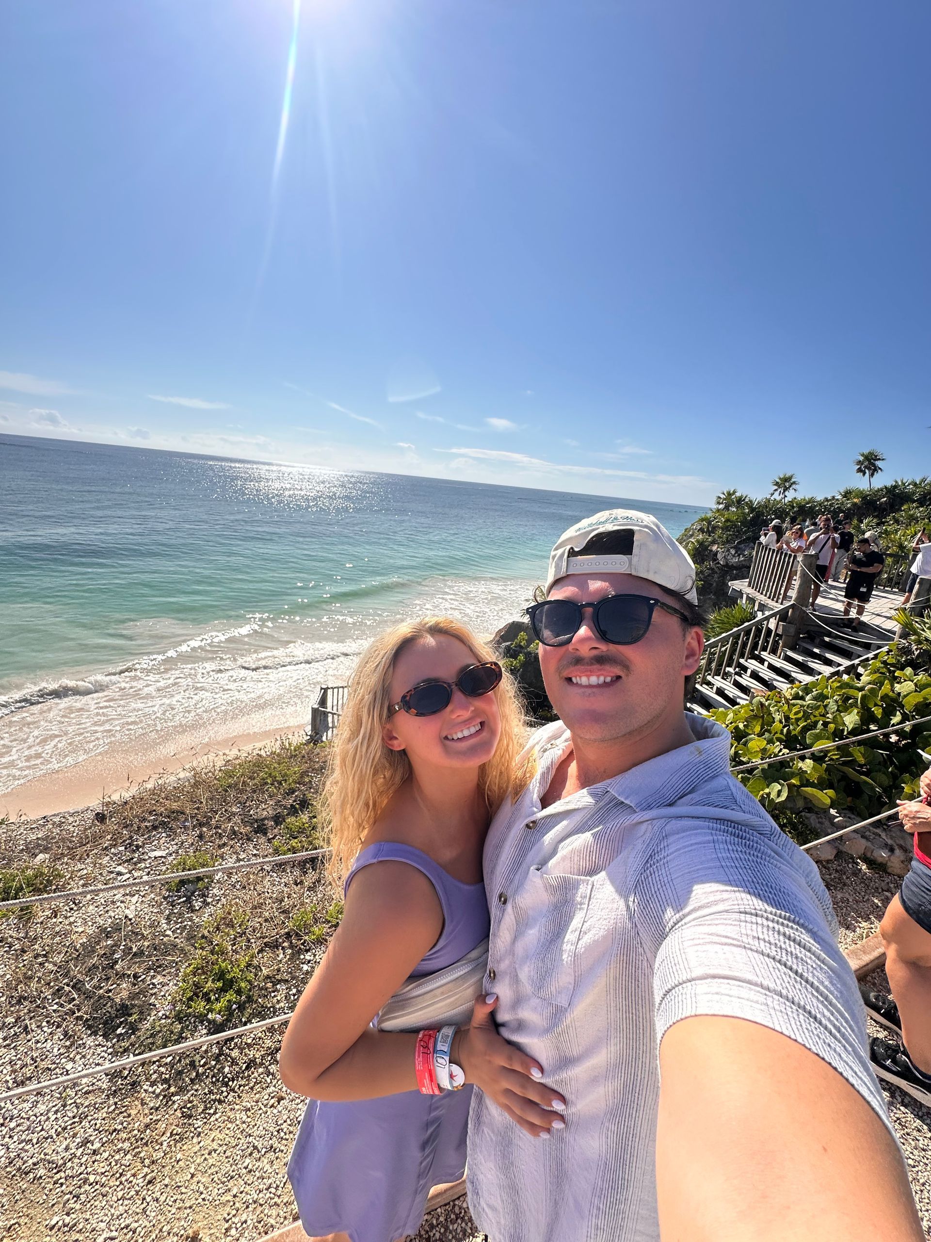 Couple taking a selfie on a sunny beach with blue ocean and clear sky