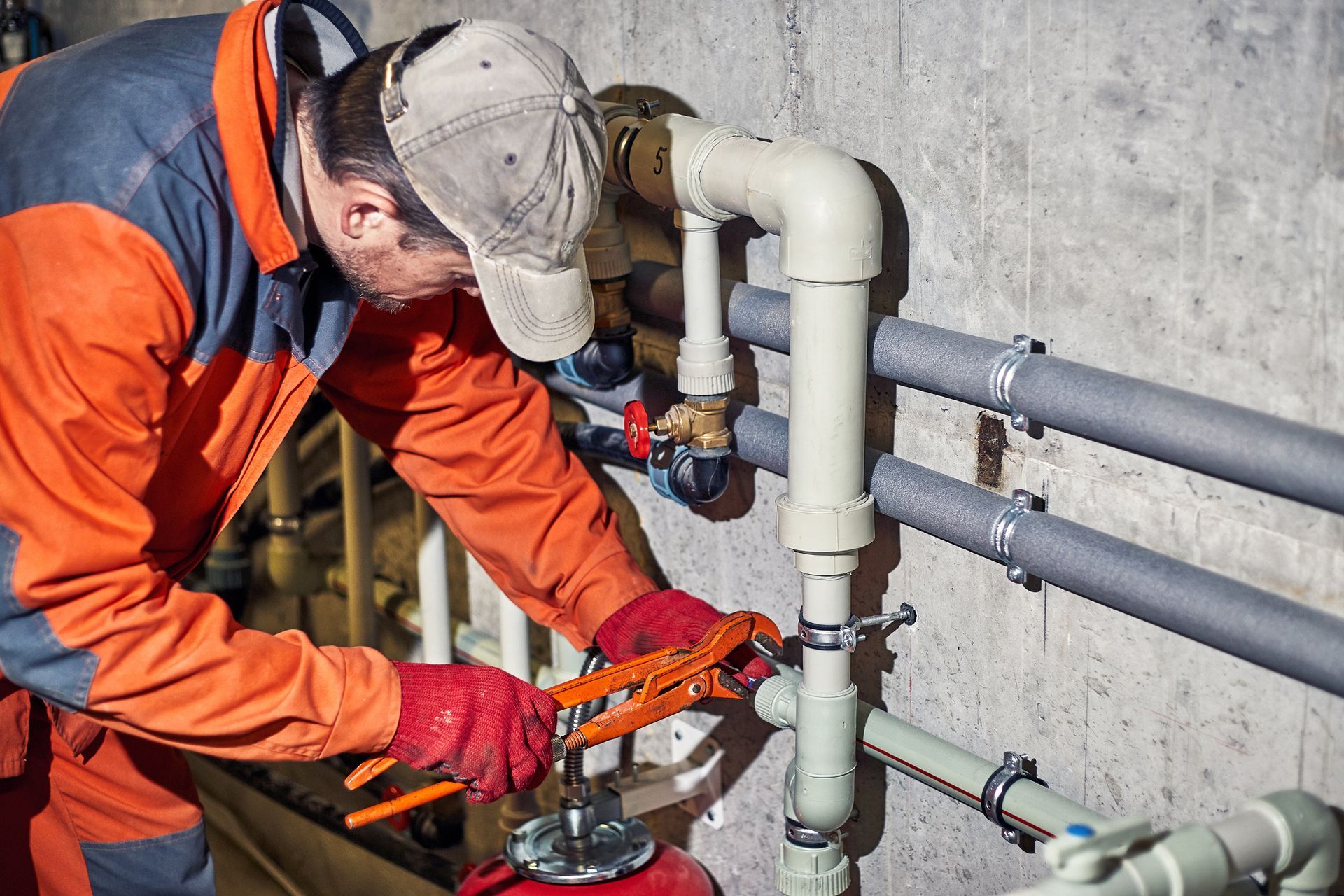 Plumber repairing pipes with a wrench.
