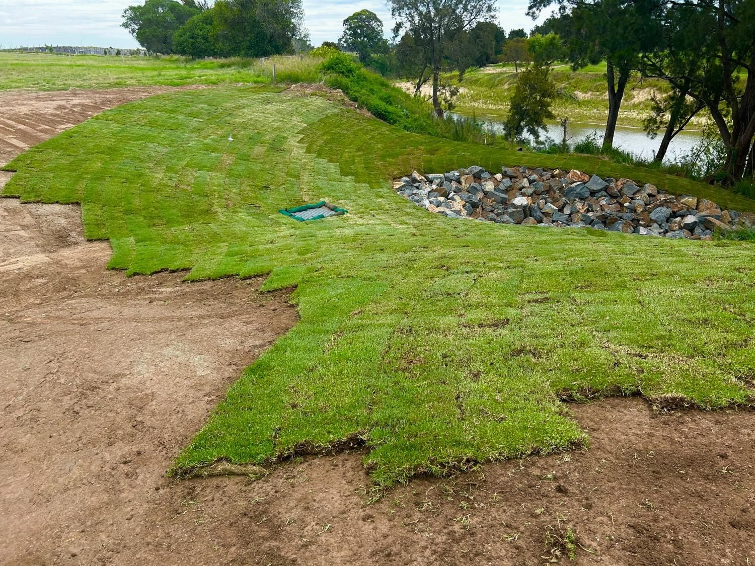 Grassy Embankment Beside a Dirt Path and Rocky Drainage — Edmonds Turf in Louth Park, NSW