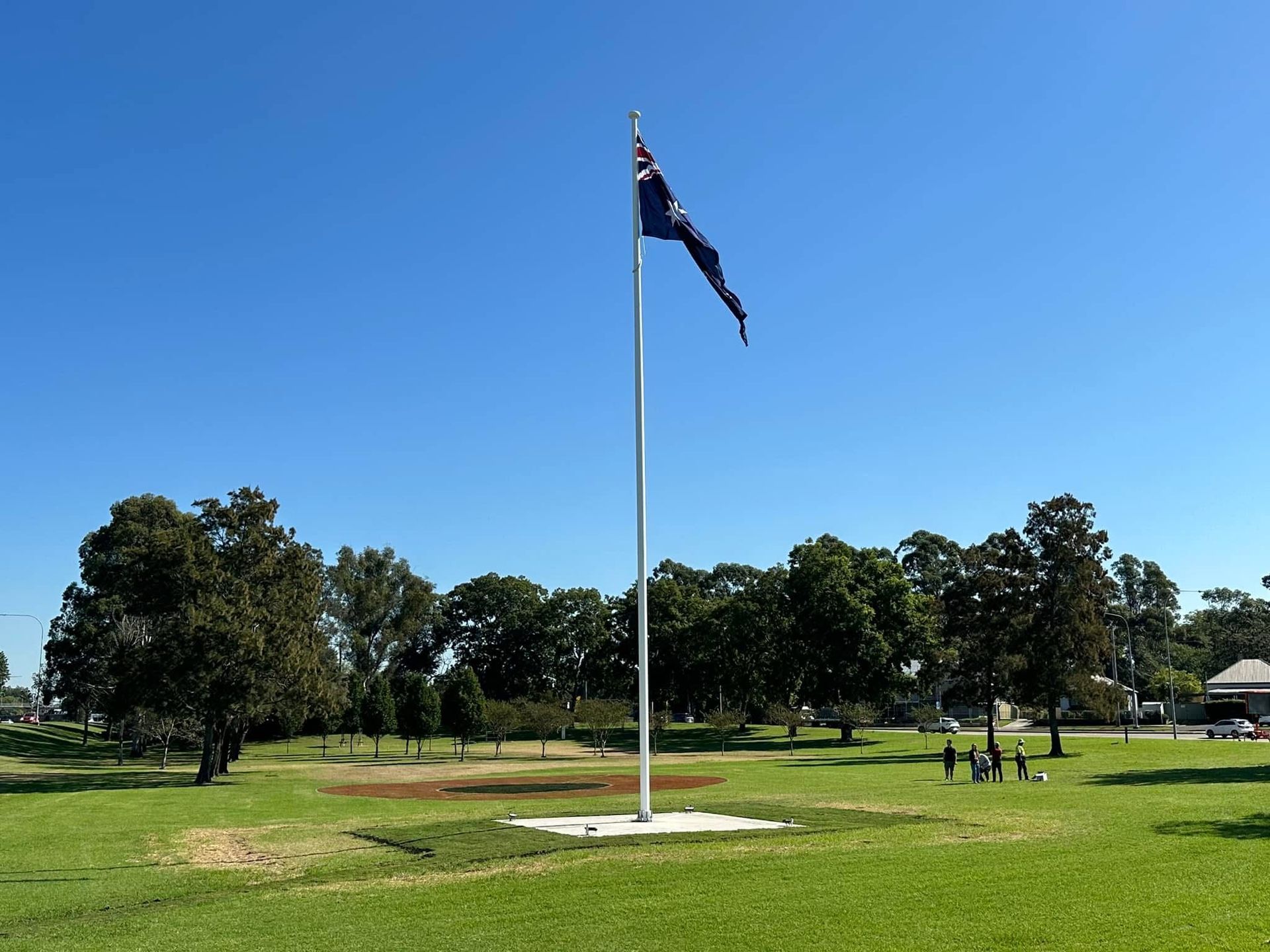 Tall Flagpole With a Dark Flag in a Green Park — Edmonds Turf in Louth Park, NSW