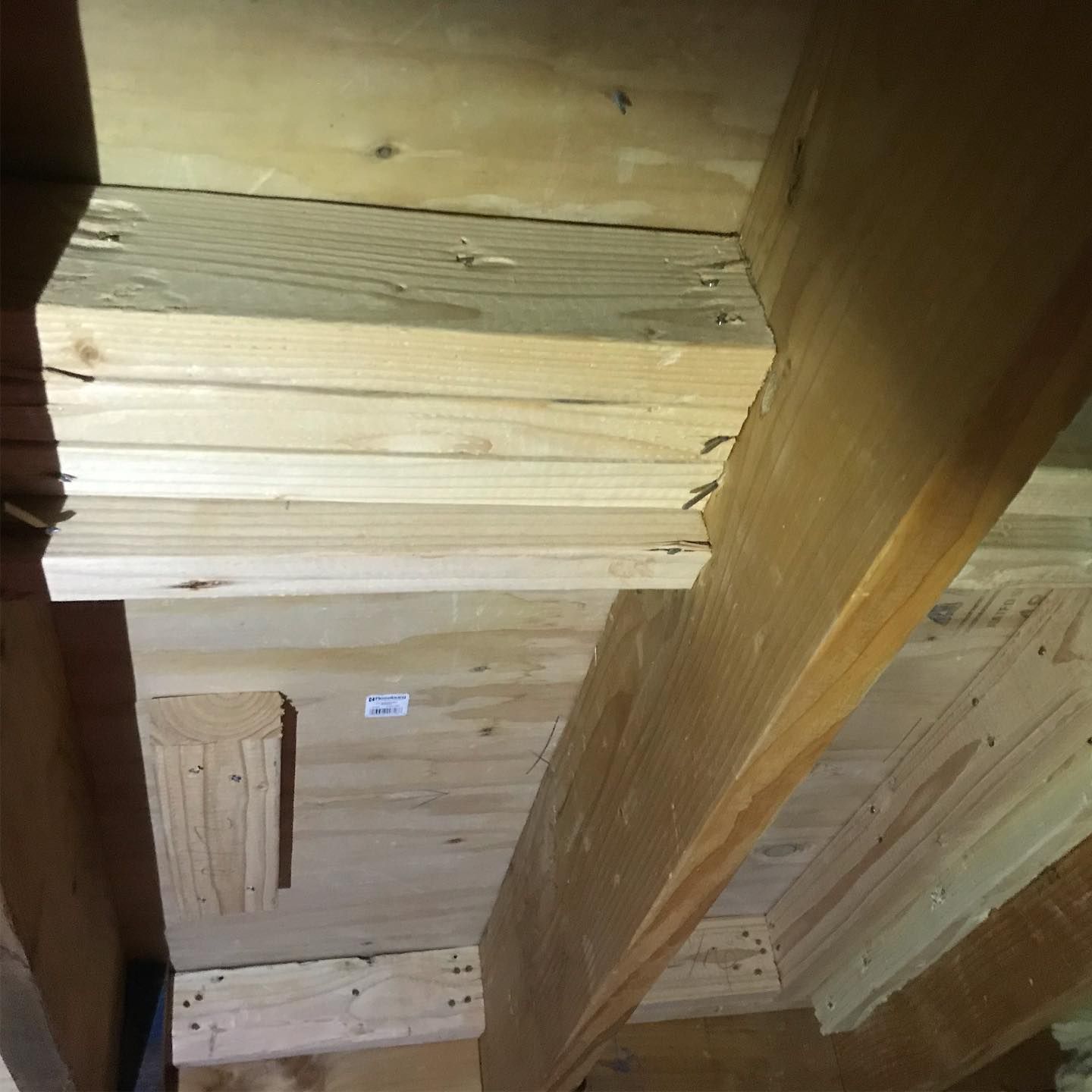 A low-angle view of raw wooden framing and structural supports inside a wall cavity.
