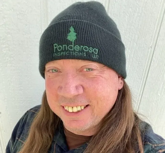 A person with long hair wearing a dark beanie with