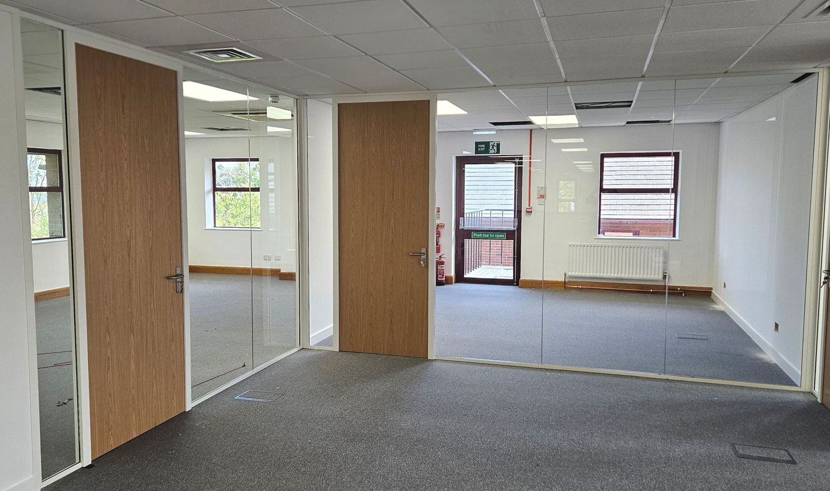 Frameless single glazed office partitions in Sunderland with timber doors