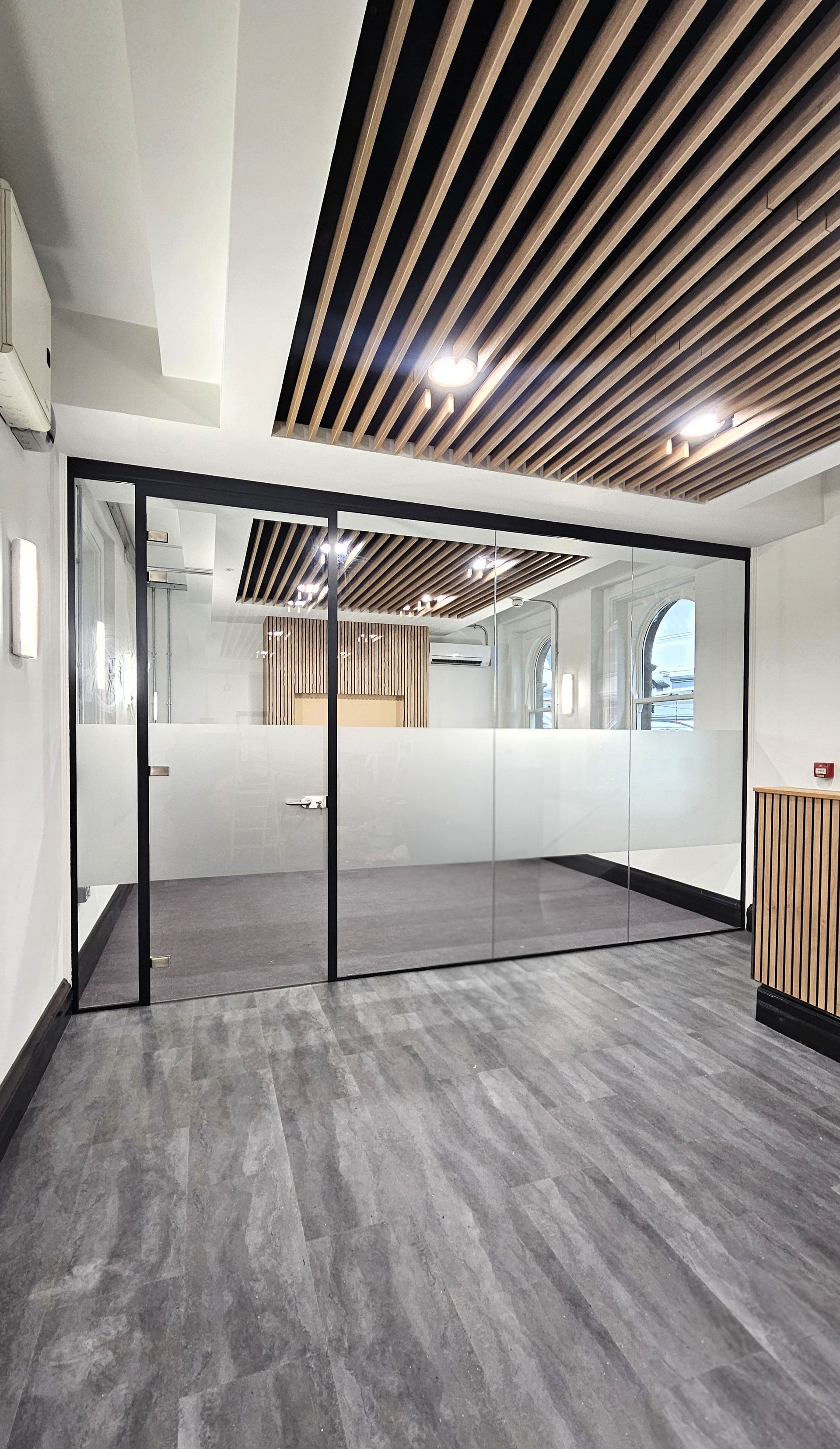 Frameless style glass partition with aluminium door frame at Newcastle Central Station