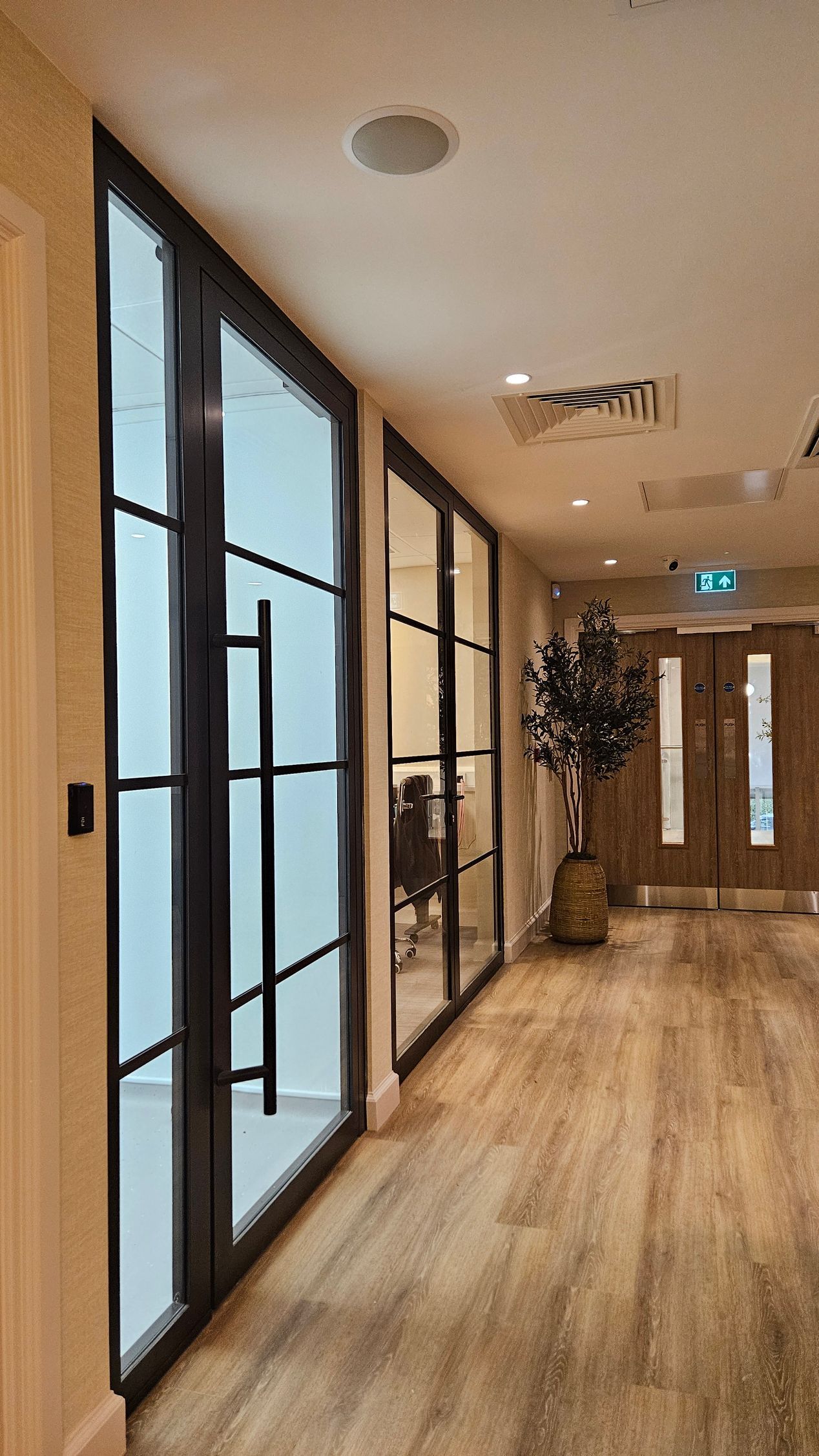 Fire rated glass office partitions with doors and side screens installed by Clear Divide Glass Partitions.