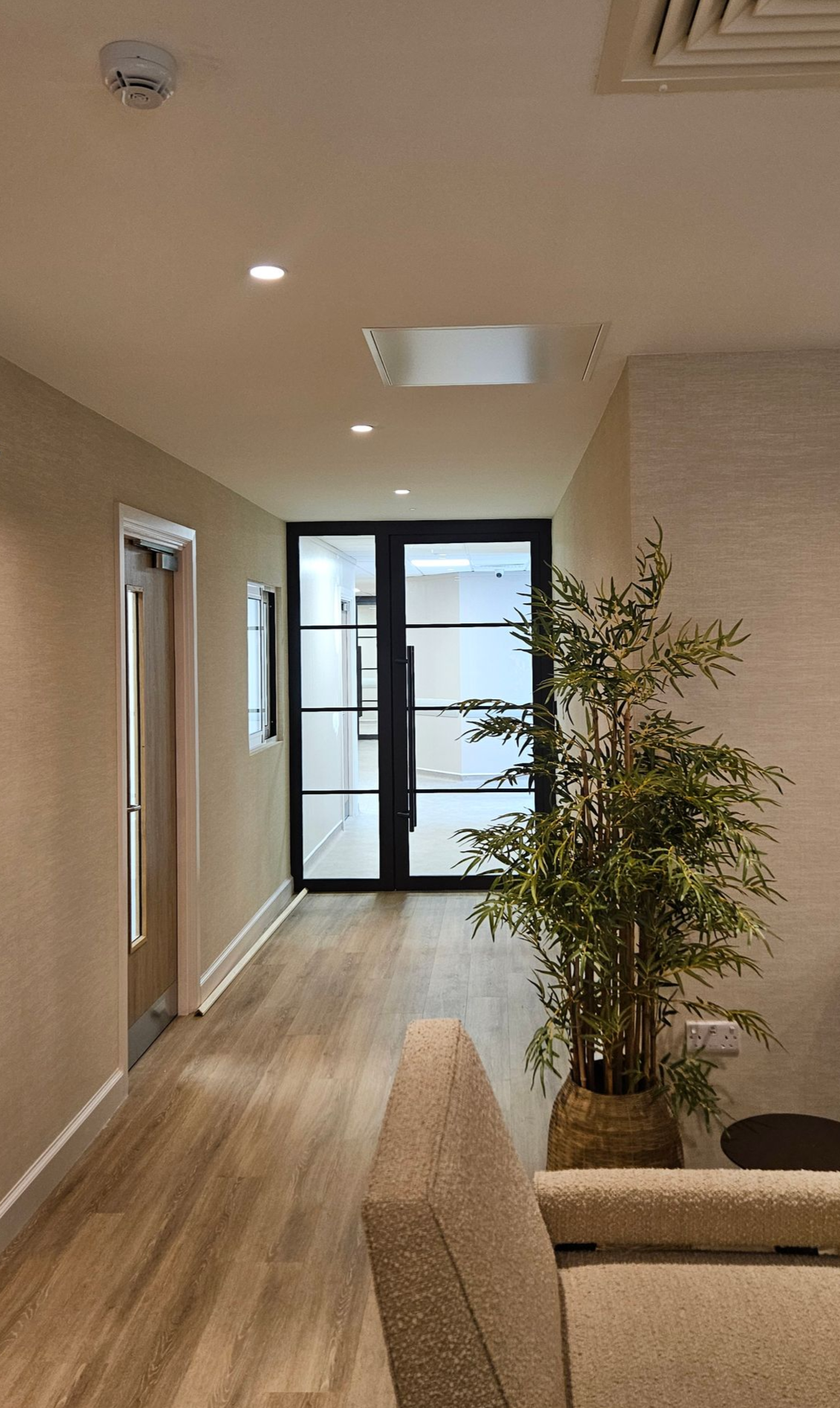 Single steel fire door with matching glazed side panel for modern private hospital.