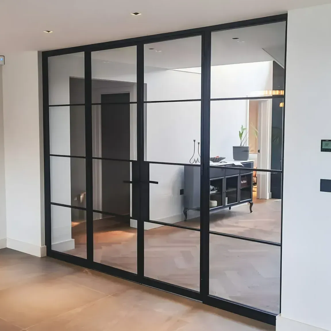 Bespoke black steel glass doors with side panels and industrial-style bars installed in a residential home