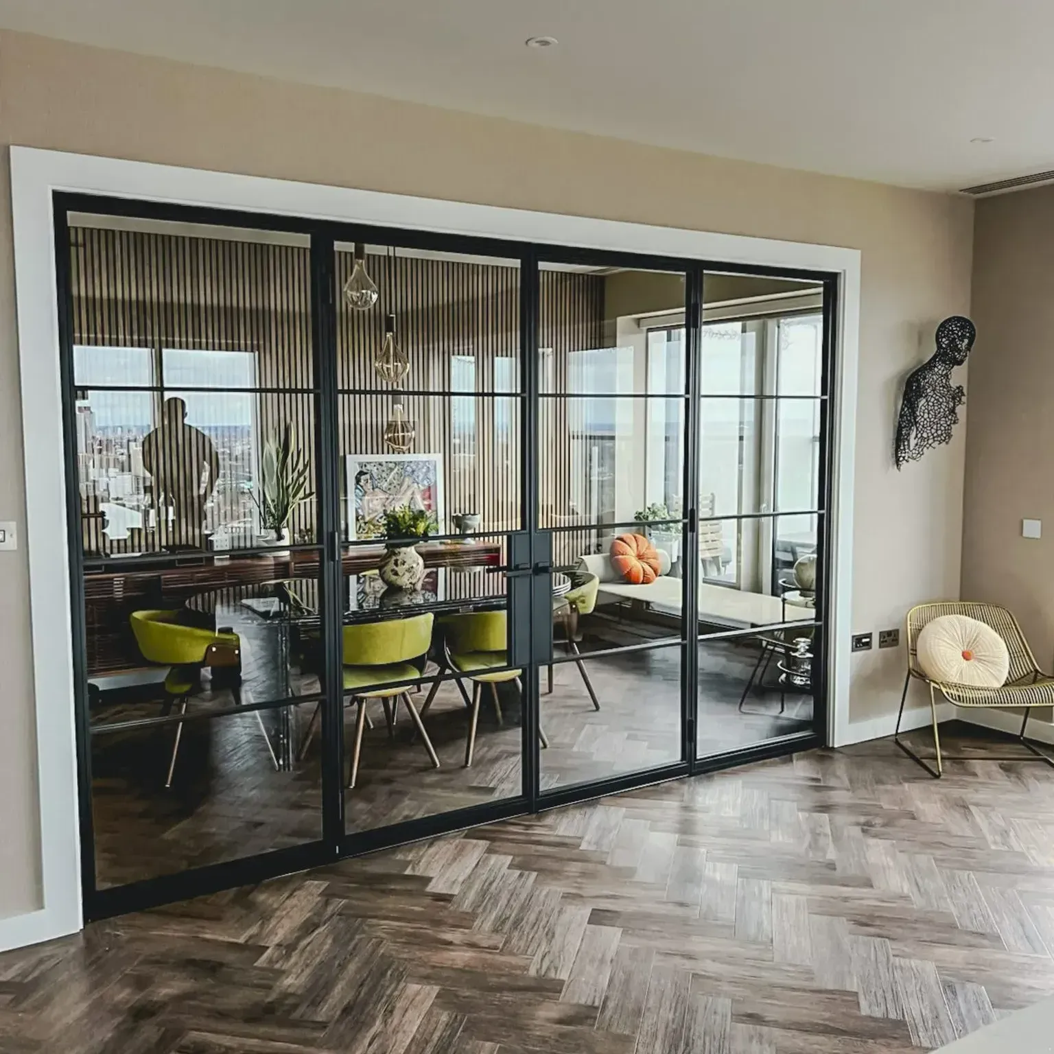 Bespoke black steel glass doors with side panels and industrial-style bars installed in a residential home