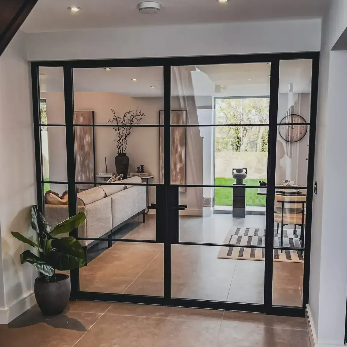 Bespoke black steel glass doors with side panels and industrial-style bars installed in a residential home
