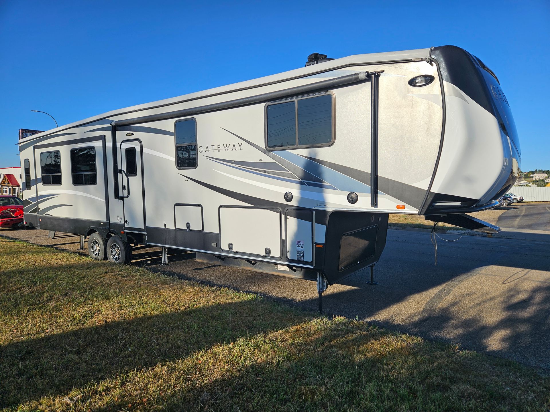 White travel trailer parked on grass in bright sunlight