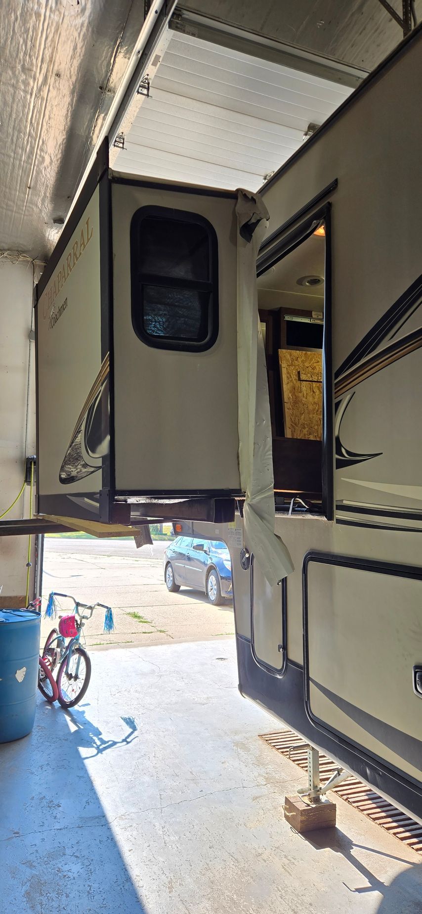 Interior doorway of a large RV or trailer, with another vehicle and a bicycle visible outside.