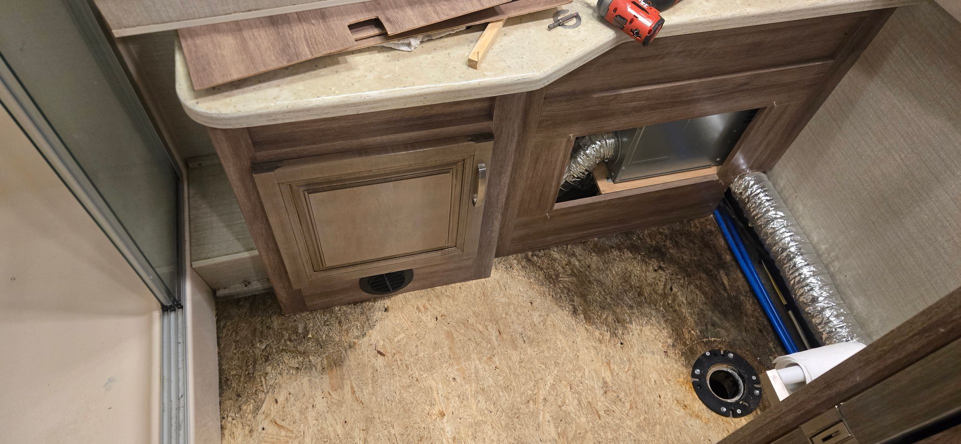 RV kitchen cabinet area with sink, countertop, and carpeted floor