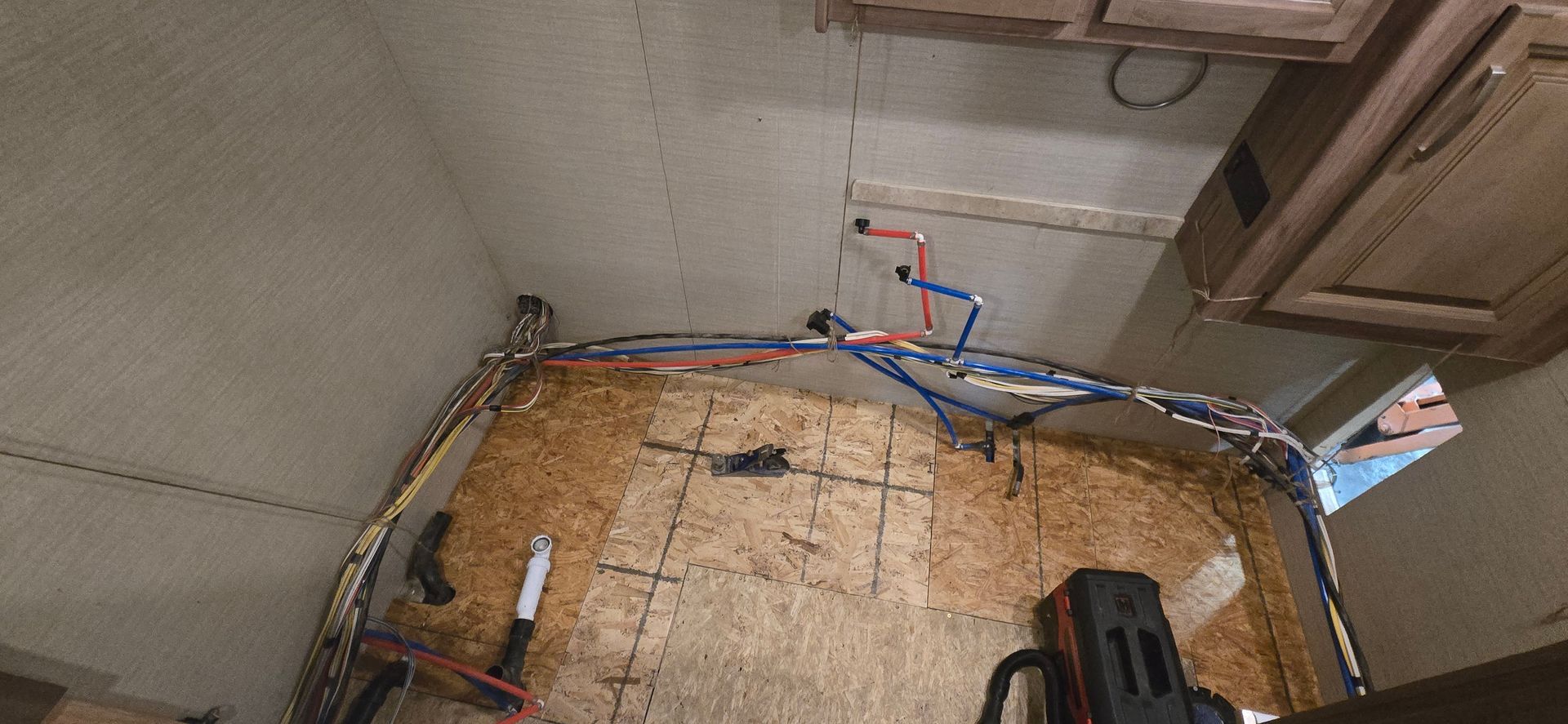 Indoor corner with exposed insulation, ducting, and tools in a partially finished room