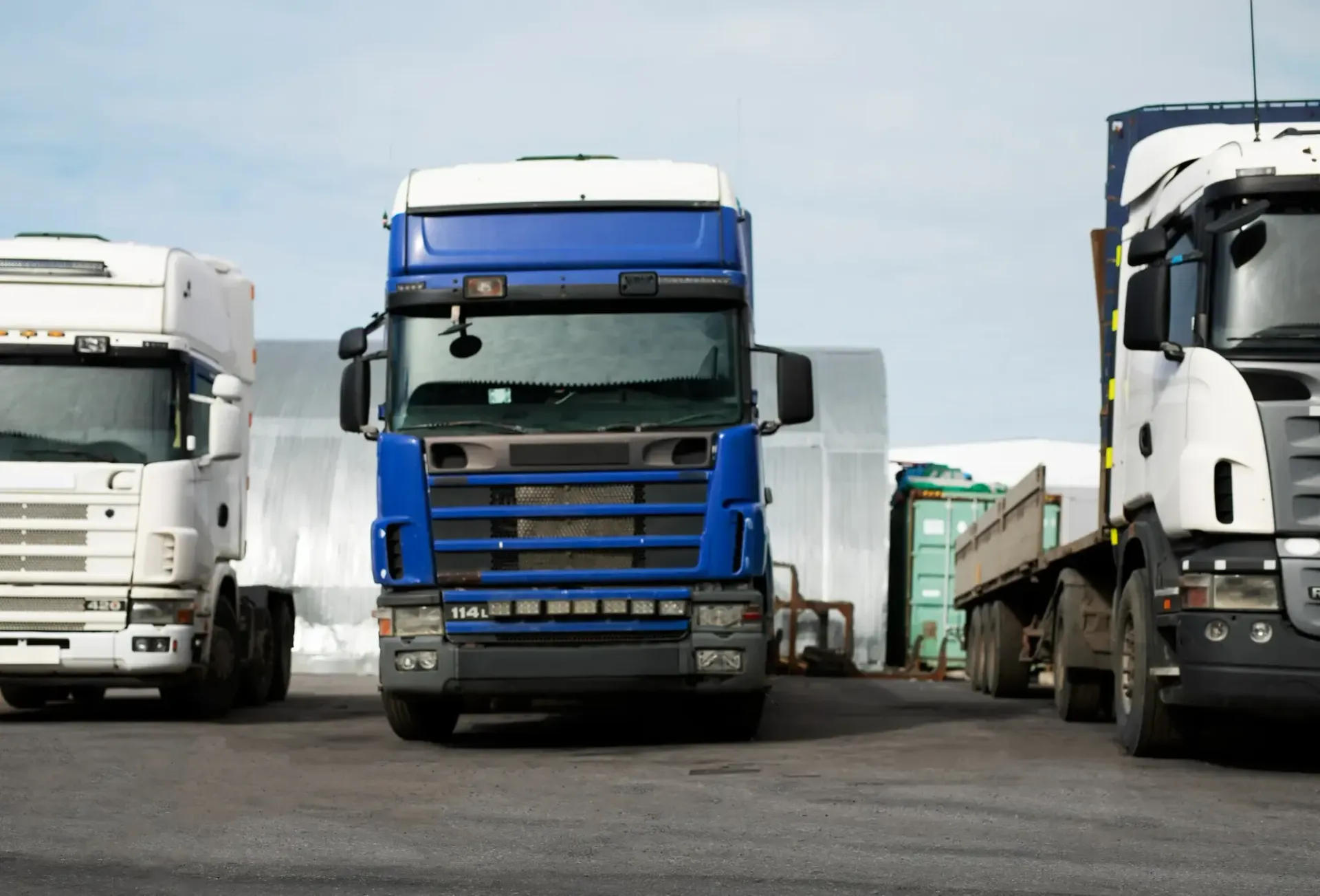 Três caminhões semirreboque estacionados.