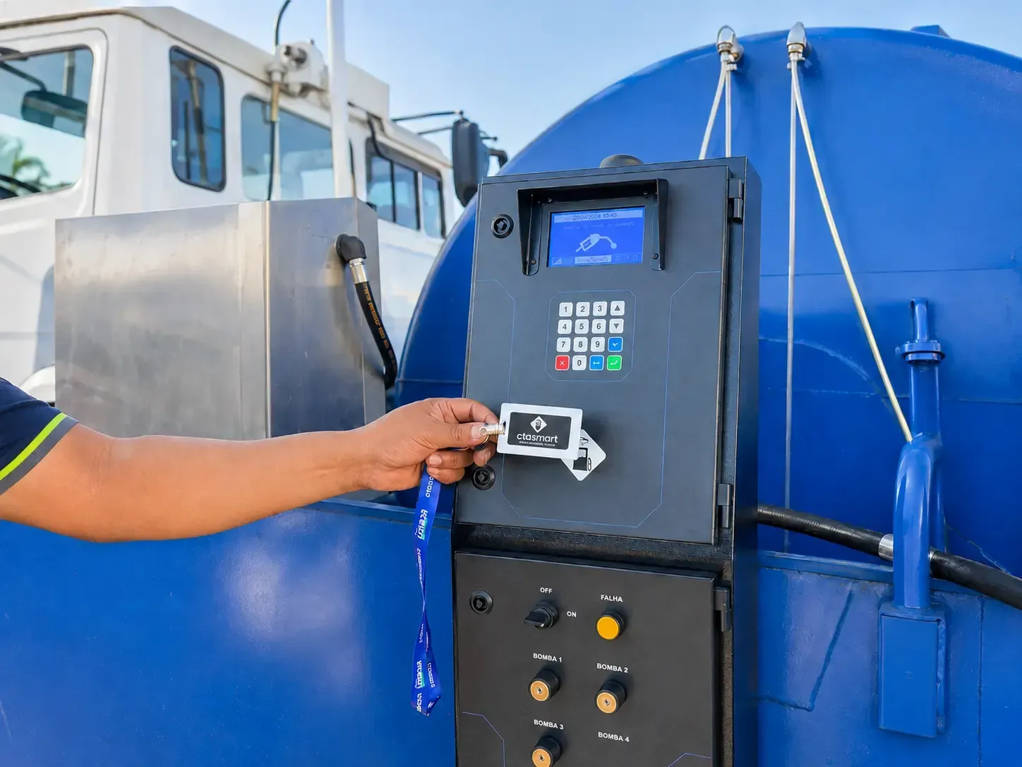 Mão inserindo uma chave em um painel de controle azul de uma máquina no convés de uma embarcação.