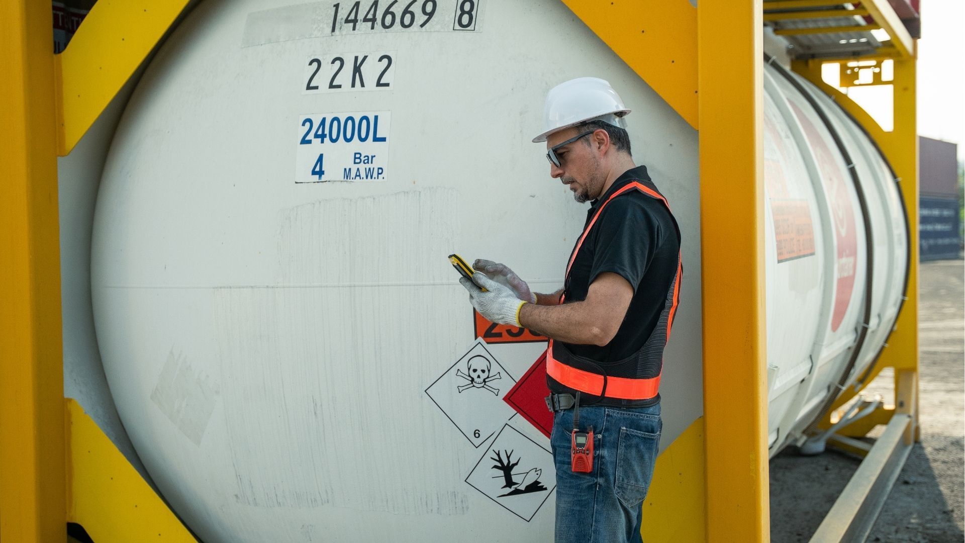 Profissional conferindo dados em tanque de combustível.