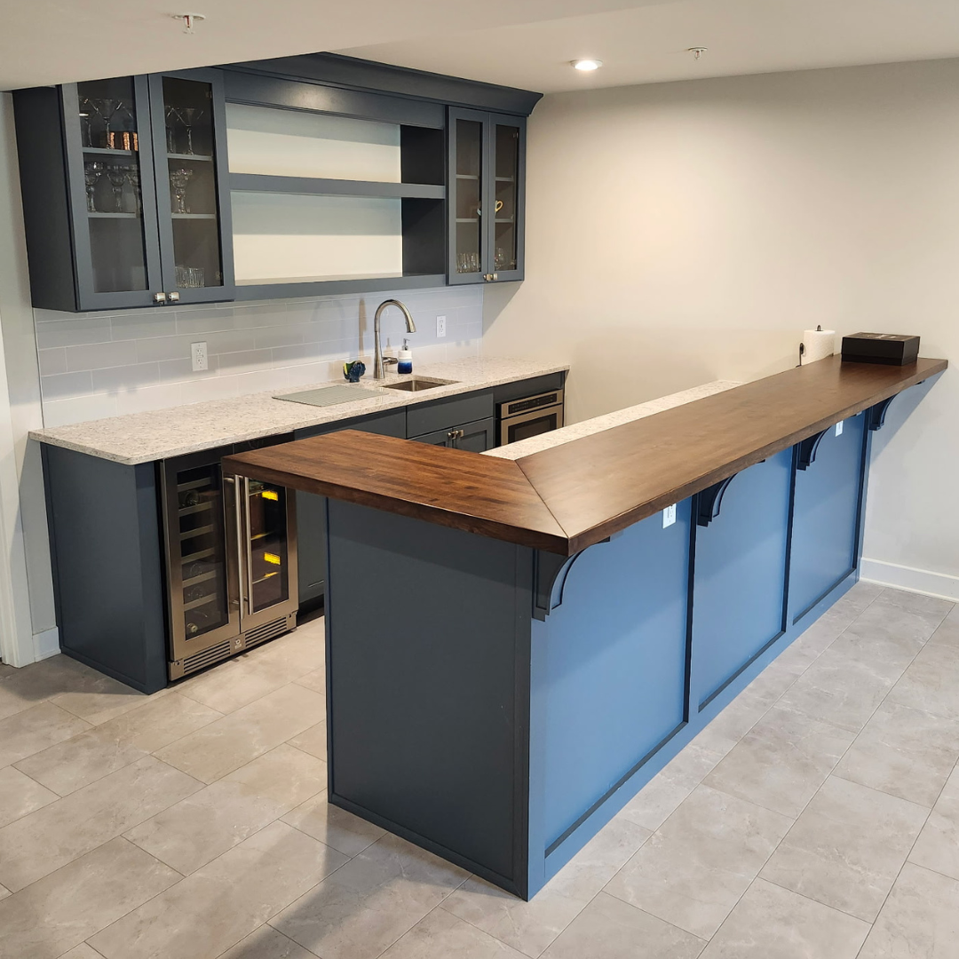Modern kitchen with blue cabinets, wood countertop island, and built-in wine cooler