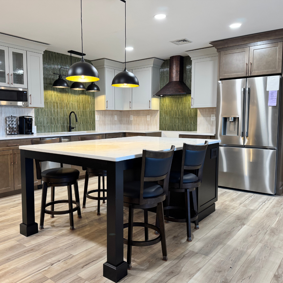 Modern kitchen with a large island, black pendant lights, and stainless steel appliances