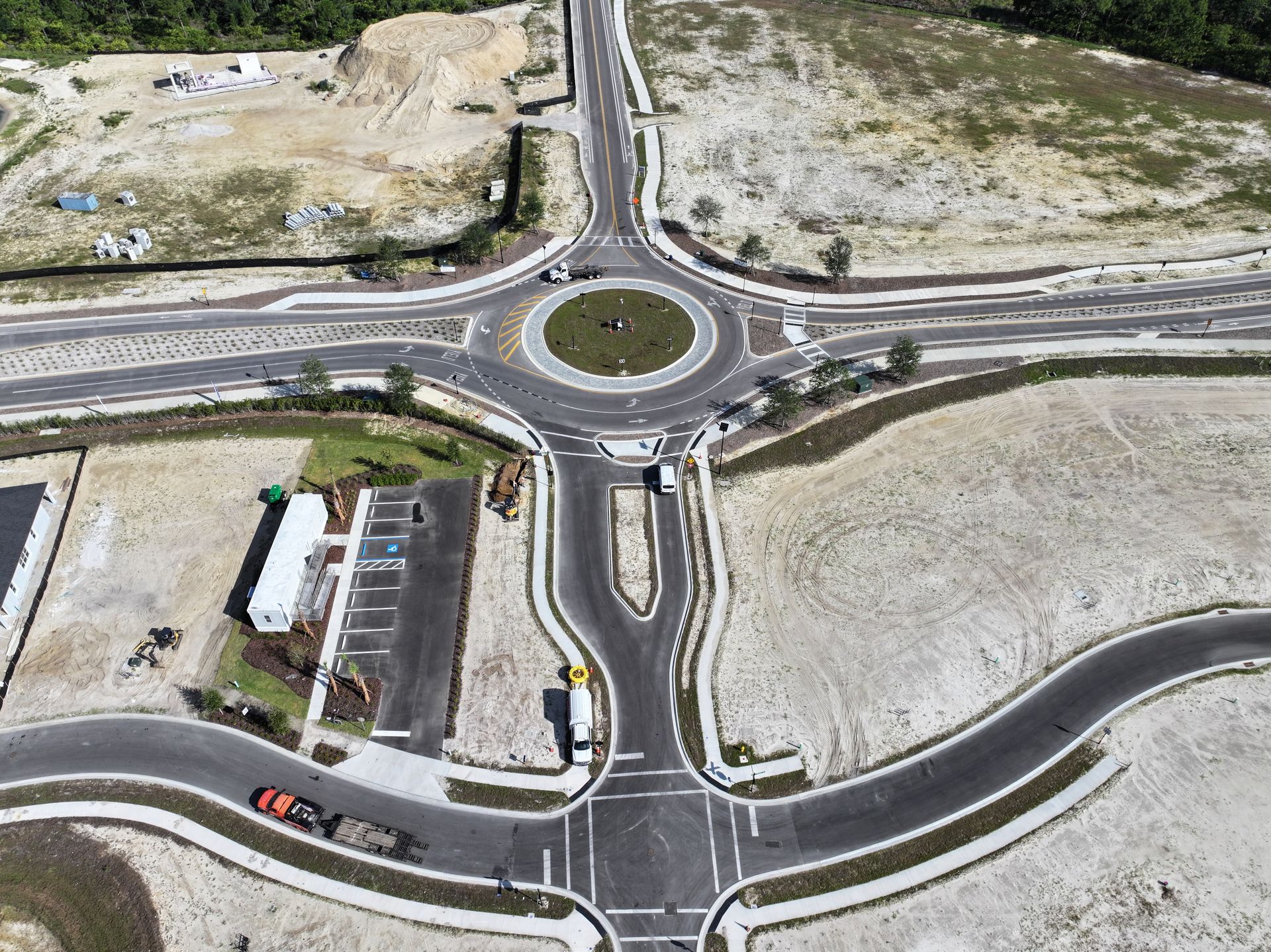 Aerial view of a roundabout connecting four roads in a dry, undeveloped area.