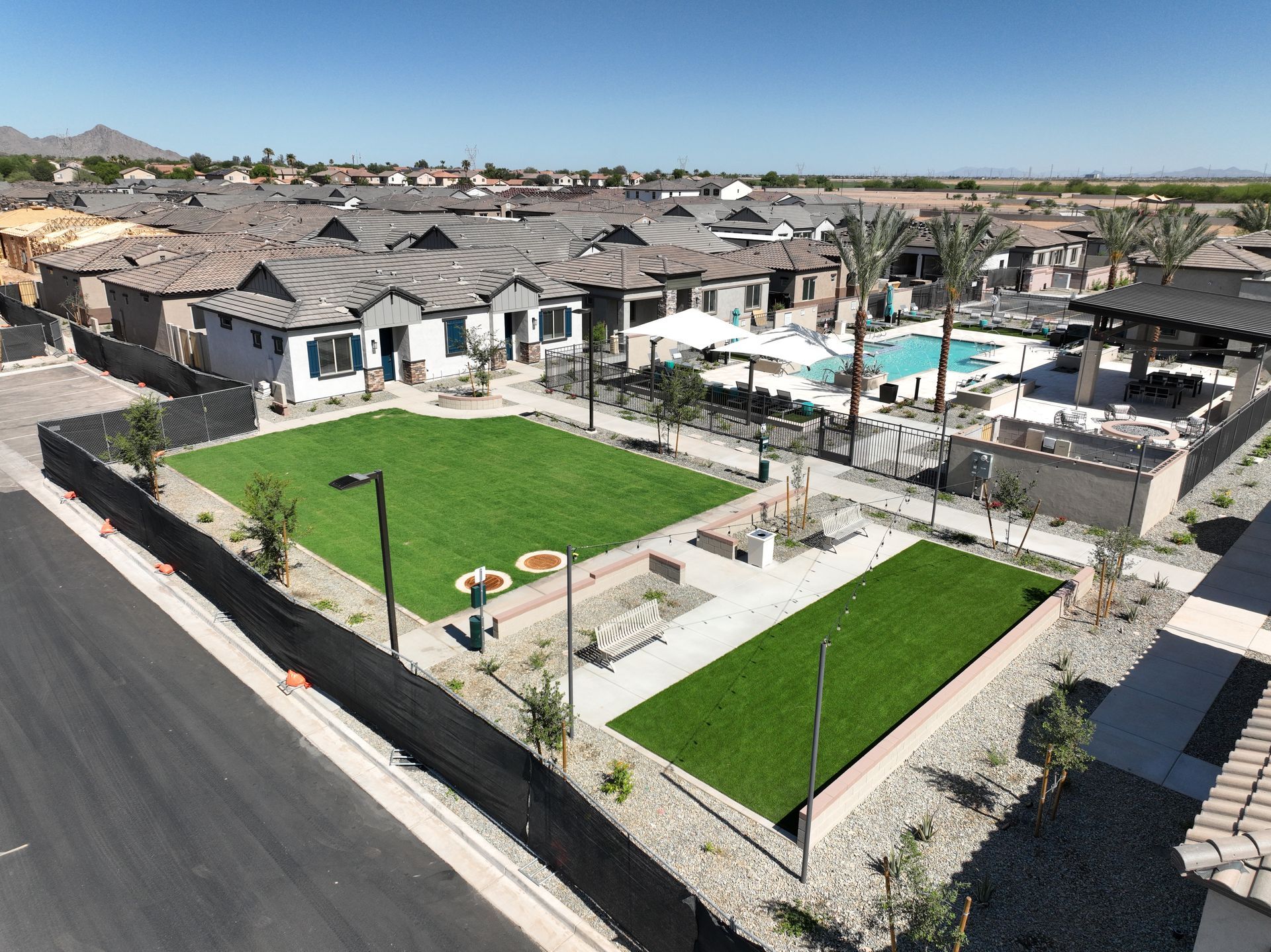 Aerial view of a large construction site with foundation trenches and dirt roads.