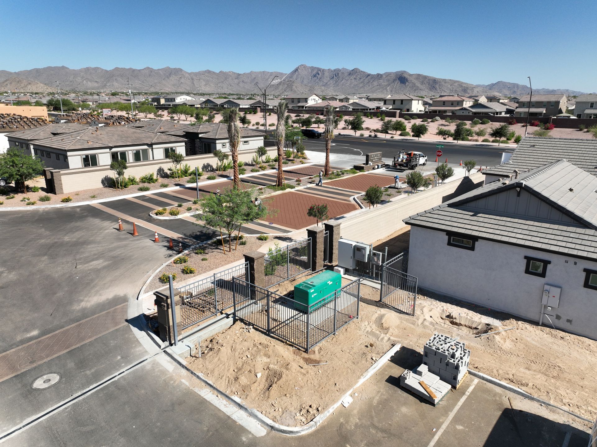 Aerial view of a suburban neighborhood with streets, houses, and a major road in a desert landscape.
