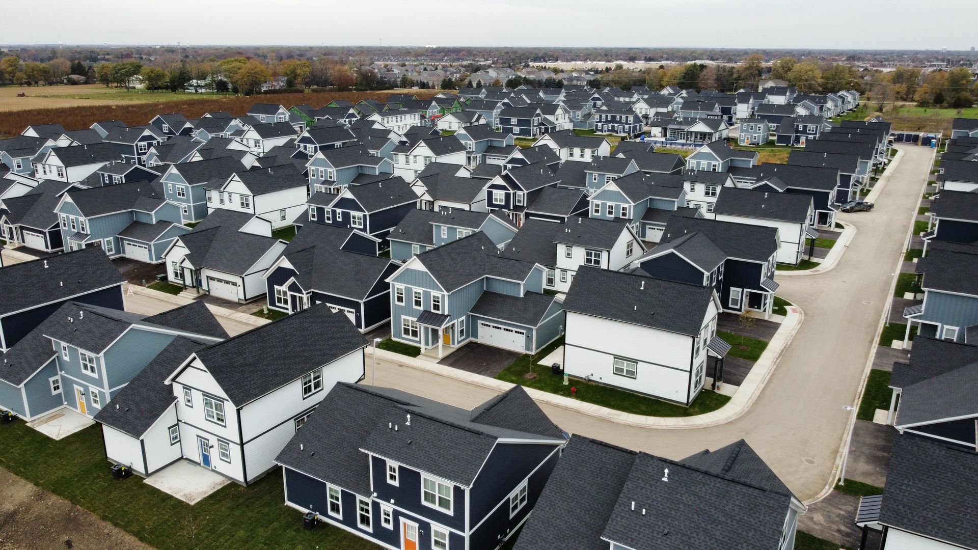 Aerial view of a suburban neighborhood with rows of modern houses and streets
