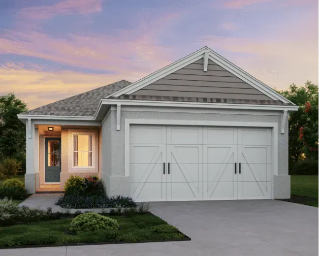 Single-story suburban house with a white garage, gray siding, and a lit front entrance at dusk