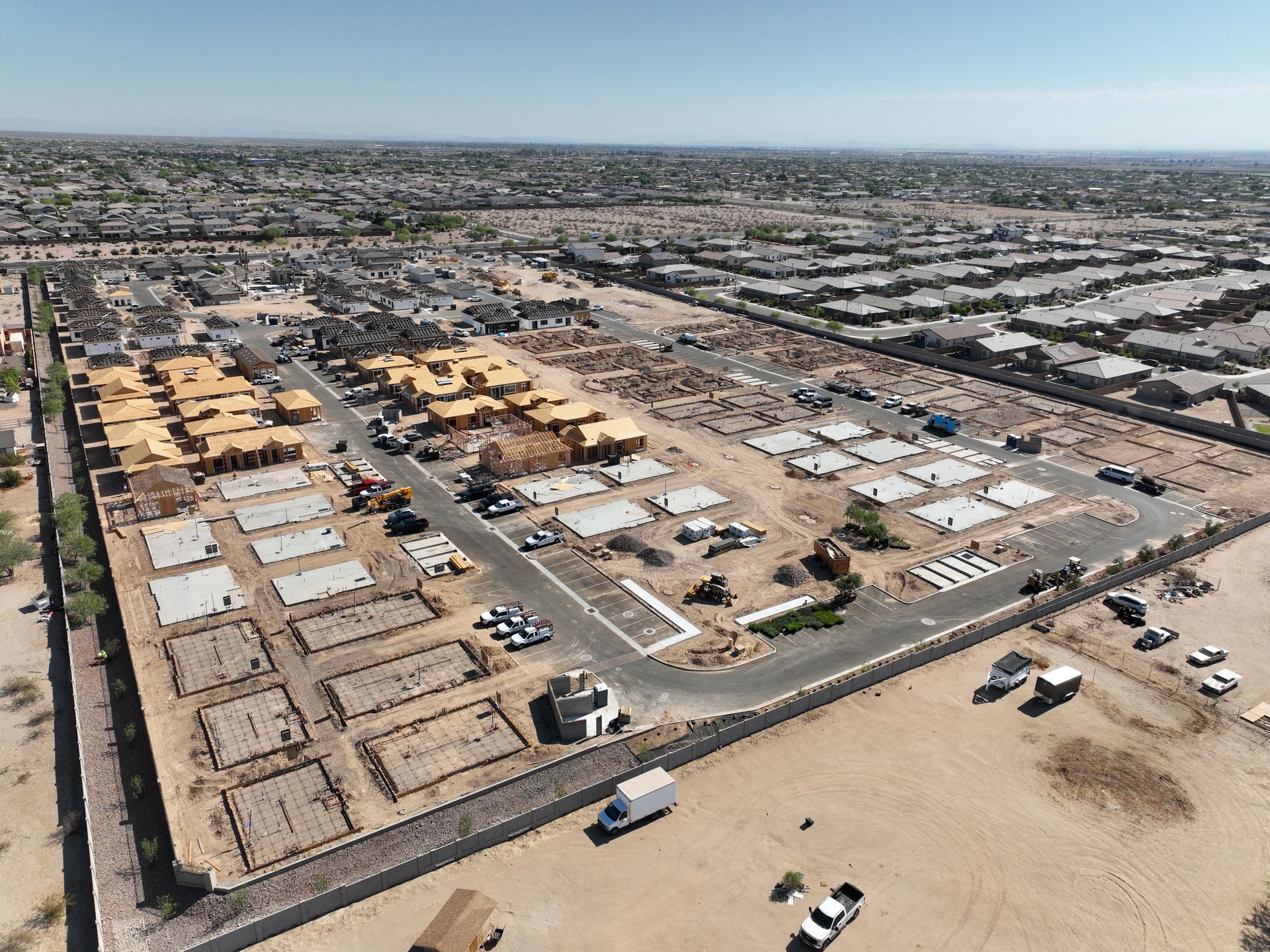 Aerial view of a suburban neighborhood with houses, streets, and mountains in the distance.