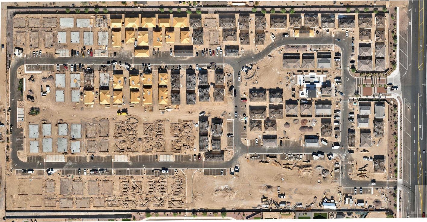Aerial view of a dense desert construction site with roads, buildings, and unfinished lots