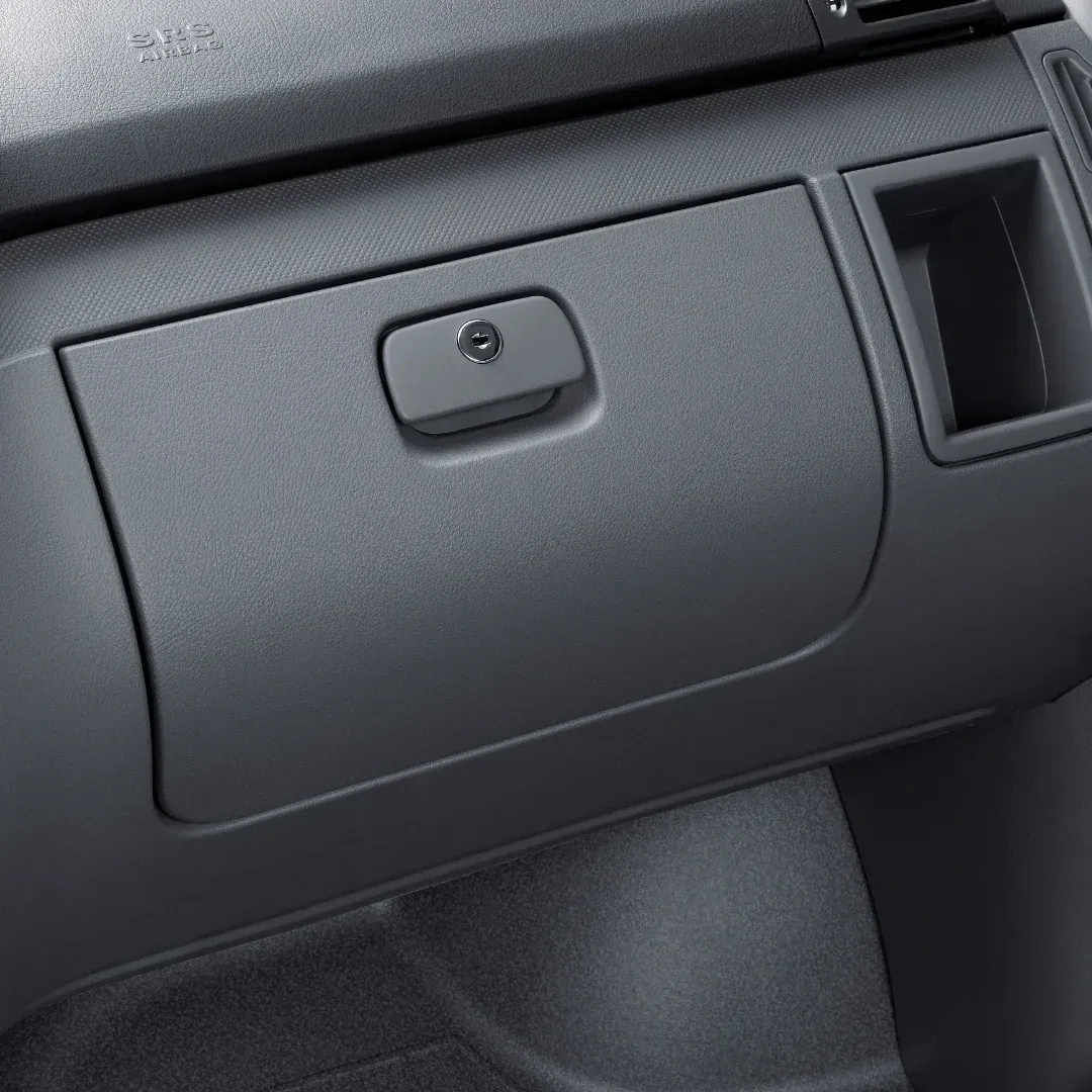 Closed gray car glove compartment on the dashboard, with a small latch and nearby air vent. Closed gray car glove compartment on the dashboard, with a small latch and nearby air vent.