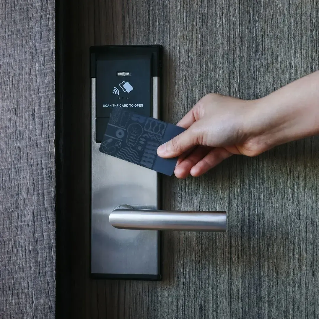 Person using an RFID key card to unlock a smart lock on a residential door in Montgomery