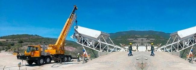 Una grúa está trabajando en una cinta transportadora en un sitio de construcción.