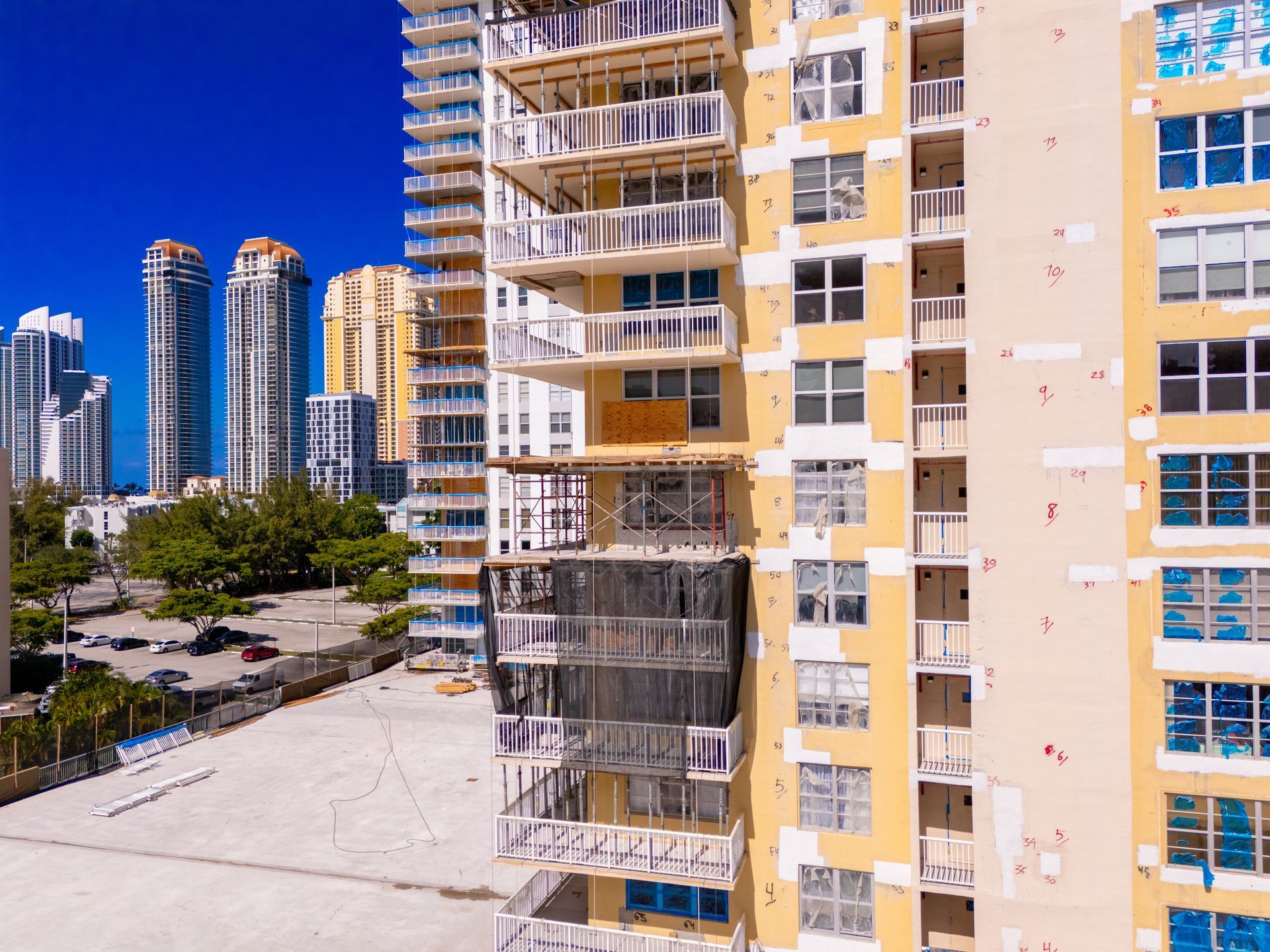 Condo restoration project showing a high-rise building undergoing exterior repairs and renovations.