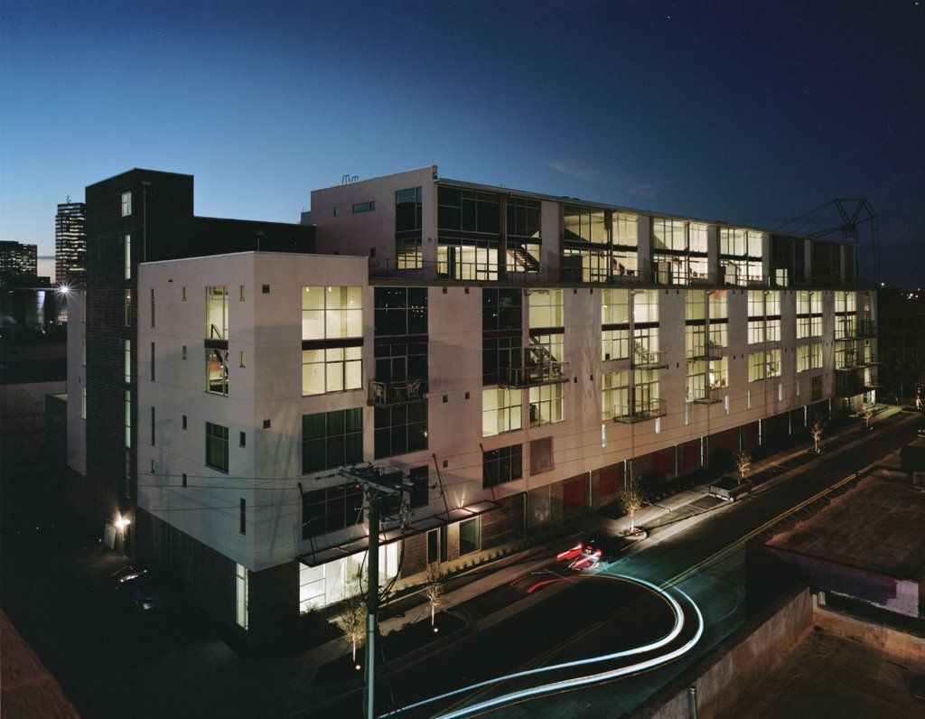 A large building with lots of windows is lit up at night